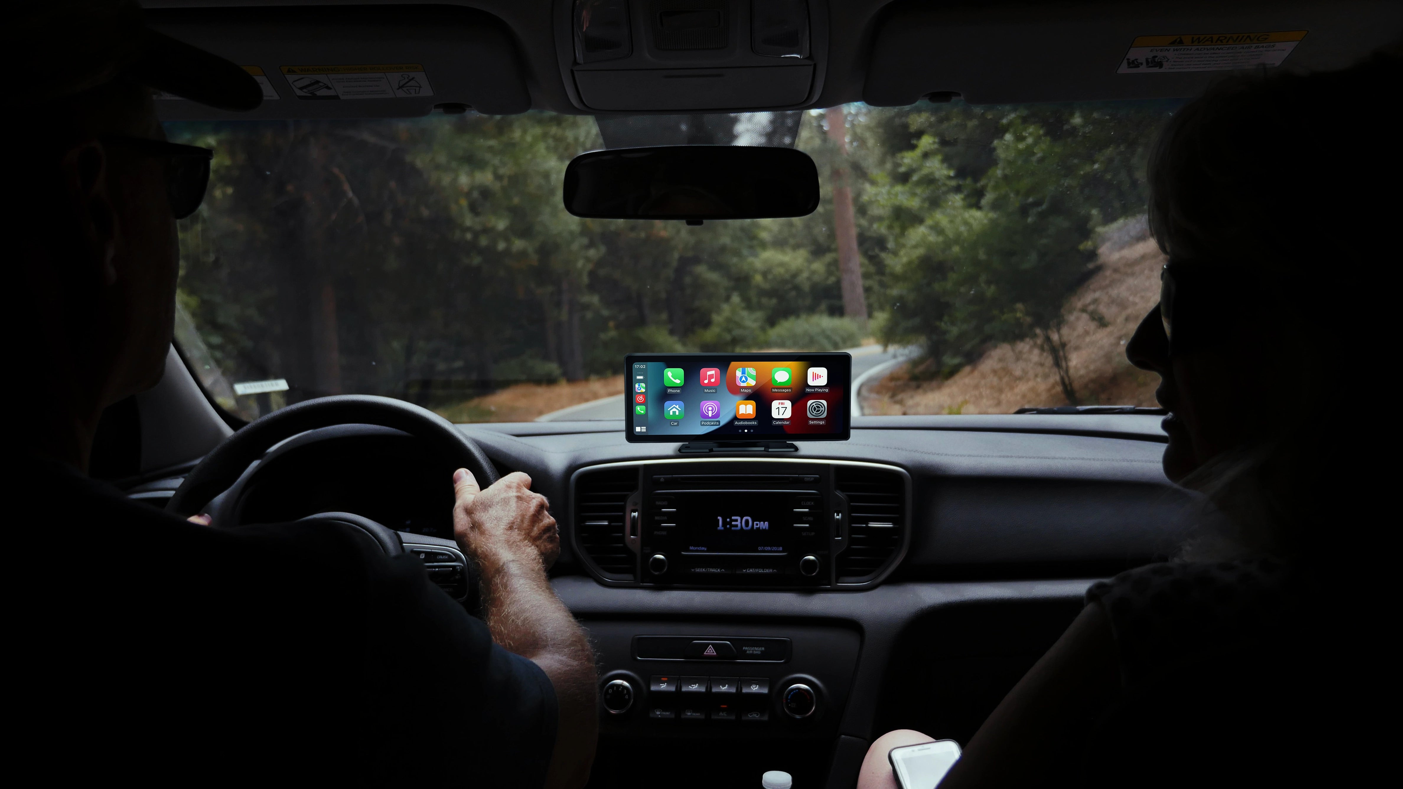 Carplay mounted on dashboard while couple is driving