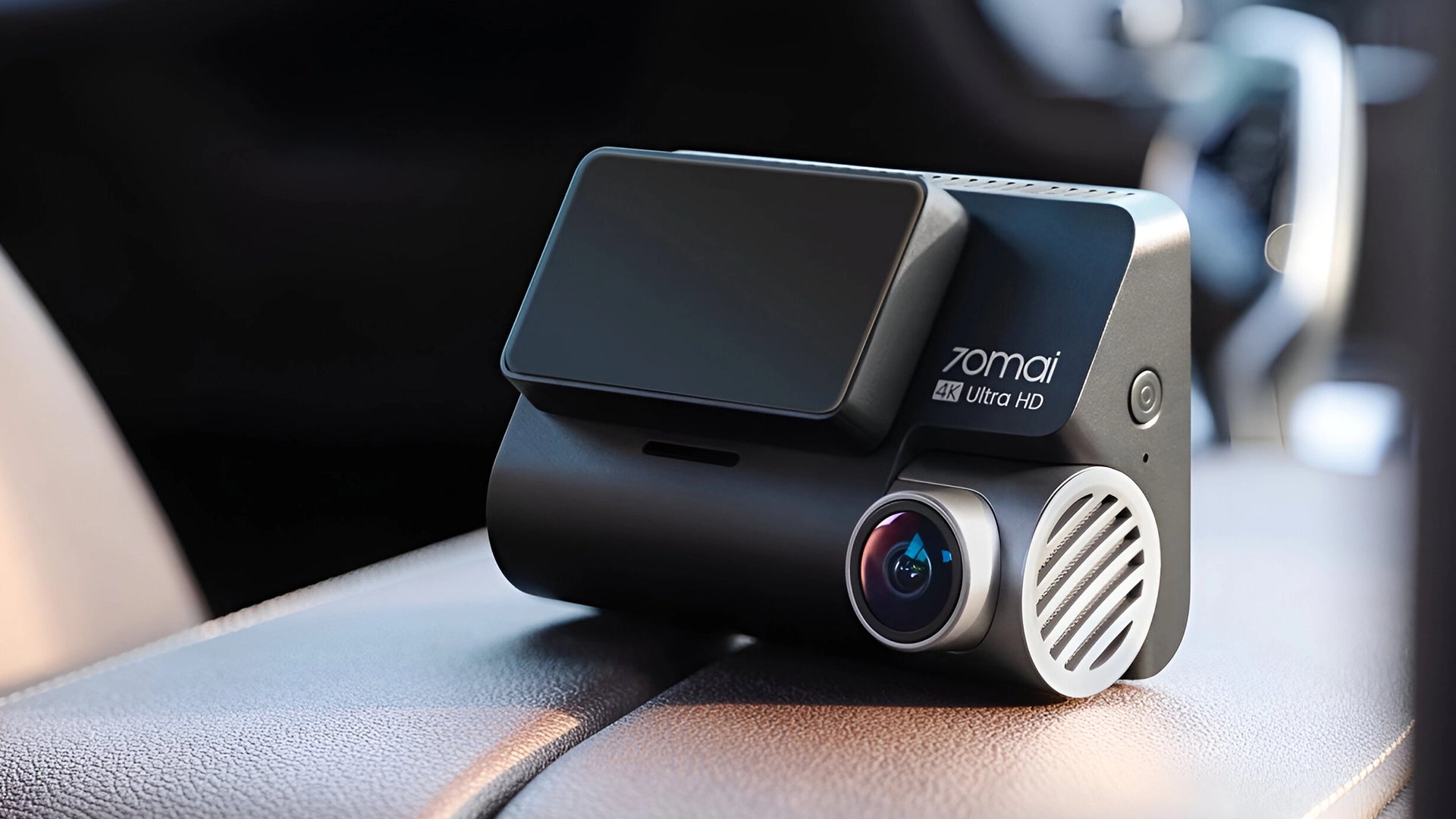 A close-up of a Zomai Ultra HD dashcam positioned on a car dashboard, with a focus on the camera lens and ventilation grill, suggesting high-quality recording capabilities